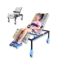 Pediatric adjustable shower chair with a child seated and secured using safety straps, featuring a reclining white support frame and rolling caster wheels.